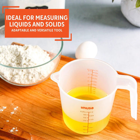 Two Cup Measuring Cup With Clear Ounces And Milliliters Markings For Liquid And Dry Ingredients next to bowl and egg on wooden surface