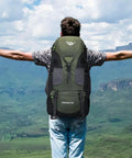 Hiker wearing Ultra Lightweight 50L Hiking Backpack For Men And Women Durable 2.2 Lb Camping Pack in scenic outdoor setting.