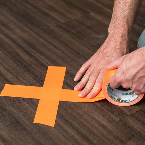Neon Orange Duct Tape 1.88 Inches Wide By 15 Yards Long Single Roll Tearable By Hand Great For Quick Fixes Repairs And Crafts Sticks To Cloth Vinyl Leather And Uneven Surfaces being applied to wood surface