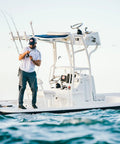 Angler on a boat using Battle Spinning Reel And Fishing Rod Combo Kit With Spare Spool And Reel Cover For Saltwater Fishing