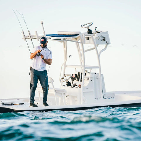 Angler on a boat using Battle Spinning Reel And Fishing Rod Combo Kit With Spare Spool And Reel Cover For Saltwater Fishing