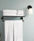 Iso 24-Inch Wide Hotel-Style Bathroom Towel Shelf With Towel Bar Matte Black Dope Modern Bath Organizer Keeps Towels Handy And Adds Sleek Everyday-Ready Style on wall with white towels.