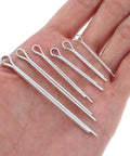 Stainless Steel Cotter Pins Assorted Sizes for Trailer Hitches and Tractor Maintenance displayed on hand for size reference