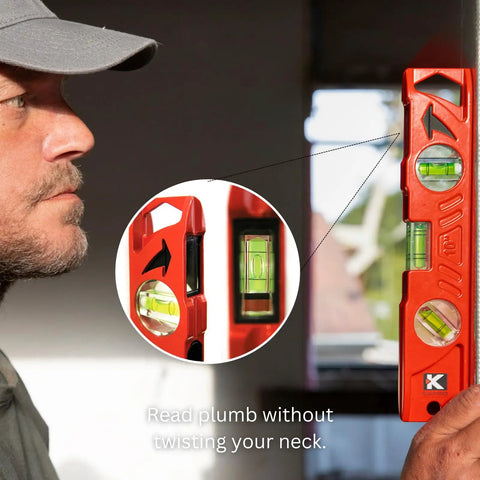 Rock Hard Professional Grade Cast Aluminum Torpedo Level With Magnetic Dual View Plumb Vial, side view showing plumb vials and user.