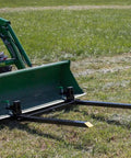 Light-Duty Fork Stabilizer Bar for 3 by 2 Inch Clamp-On Forks attached to green tractor bucket in field