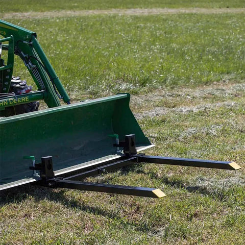 Light-Duty Fork Stabilizer Bar for 3 by 2 Inch Clamp-On Forks attached to green tractor bucket in field