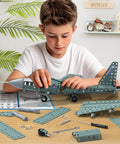Boy assembling Metal Airplane Model Kit For Kids 8 9 10 11 12 Teens Hands On DIY STEM Building Toys with tools on table