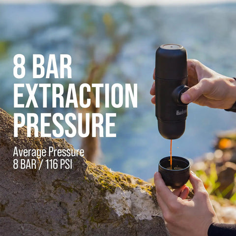 Minipresso GR Portable Espresso Machine For Ground Coffee being used outdoors, showing hand-press operation with espresso flow.