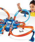 Child playing with Hot Wheels Criss Cross Crash Track Set With 1 To 64 Scale Car Four Intersections Motorized Booster