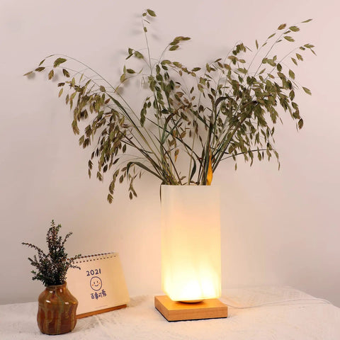 Vase Table Lamp With Frosted Glass Shade And Wood Base Dimmable 3 Color LED Bedside Light USB Charge Artistic Vase Lamp glows softly on a tabletop.