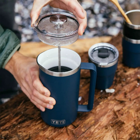 Person using Rambler 34 Oz French Press Coffee Maker With Grounds Control Filter Navy Double Wall Vacuum Insulation outdoors