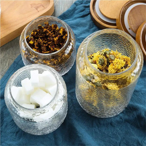 Keep Your Stash Fresh With These Top Notch Sealed Tea Canisters And Coffee Bean Jars Crafted From Durable Glass Super Simple Kitchen Pantry Storage Essentials That Are Actually Worth The Buy Hella Convenient: Three glass jars containing sugar cubes and dried tea herbs.