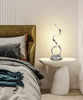 Modern Spiral LED Table Lamp with Dimmable Touch Control and USB Port 22W Reading Light on bedroom nightstand, lit, curved design.