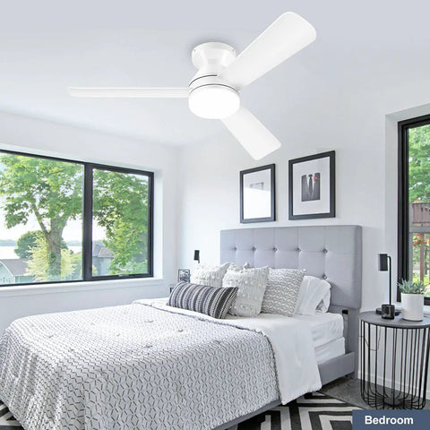White flush mount low profile 42 inch ceiling fan with light and remote reversible motor in modern bedroom