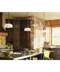 Archie Collection One Light Pendant In Venetian Bronze With Clear Prismatic Glass above modern kitchen island.