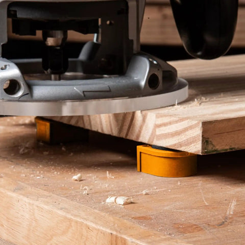 Heavy Duty Three Quarter Inch Aluminum Workbench Dogs Eight Pack With Grippy Pads under a routed board, showing grip in action.