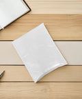 Waterproof Bubble Mailers 10 Pack Self Seal Padded Envelopes 40x50 CM on table, shown with pen and notebook for scale
