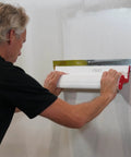 Person using 24 Inch Composite Skimming Blade For Drywall Mud And Plaster Finish, Pro Grade Replaceable 0.3mm German Stainless Steel Blade Insert