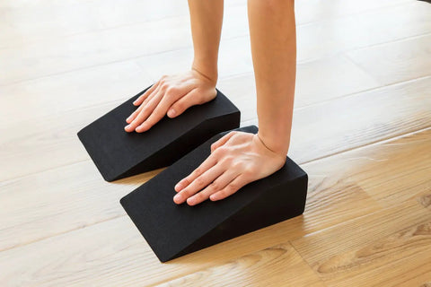 High Grade Foam Yoga Wedge Blocks Set Of Two With Carry Bag Multi Angle Incline support during a deep stretch on wooden floor.