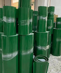 Stacks of green PVC conveyor belts, 10x370cm, for assembly lines and warehouse workflows, featuring polyester reinforcement.