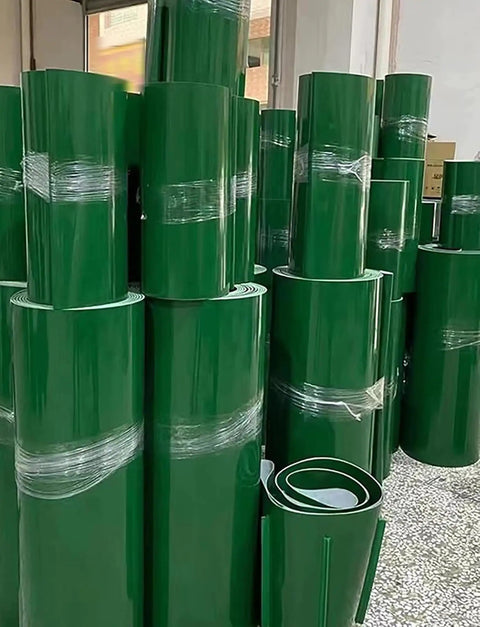 Stacks of green PVC conveyor belts, 10x370cm, for assembly lines and warehouse workflows, featuring polyester reinforcement.