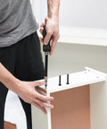 Man using a driver to install Heavy Duty Black Hex Socket Bed Screws Replacement Kit With 141 Pieces And Matching Nuts for furniture assembly.
