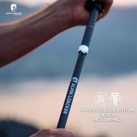 Close-up of hand holding Ultra Lightweight Aluminum Collapsible Trekking Poles With Cork Grips, showing patented lock button.