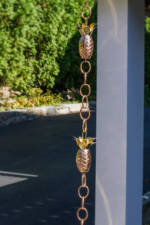 Copper Pineapple Rain Chain Eight And A Half Foot Long Handcrafted 20 Gauge Pure Copper With Brass Accents hanging outdoors