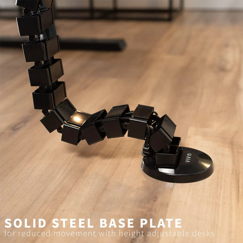 Black clamp on desk cable management kit with vertebrae system, no drill, quad entry cord organizer, on wood floor, home office.