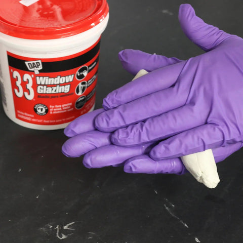 Window Glazing Compound For Wood Metal And Aluminum Sash White 16 Oz with gloves handling the compound for glazing.