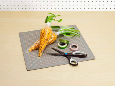 Crafting supplies on table with scissors, cutting mat, green ribbon, snack bags, Gold Glitter Washi Tape Pack of 6 nearby.