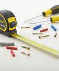 Fatmax Tape Measure With Blade Armor And Dual Scale 8m Length displayed with screws and tools, Mylar coated blade extended.