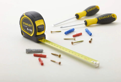 Fatmax Tape Measure With Blade Armor And Dual Scale 8m Length displayed with screws and tools, Mylar coated blade extended.