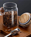 Go Ahead And Upgrade Your Countertop Setup With This Solid Clear Glass Storage Jar Featuring An Airtight Sealed Kitchen Canister And Wooden Spoon For Coffee Beans 900Ml Capacity with coffee beans.
