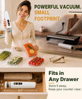 Handheld Food Vacuum Sealer Cordless Compact Sealer With 30 Reusable Bags on counter with sealed vegetables and salmon
