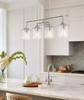 Monroe 28 Inch Modern Four Light Linear Kitchen Island Light with Hammered Glass Shades in Brushed Nickel over kitchen island.
