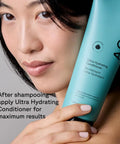 Woman holding green tube of Ultra Hydrating Shampoo For All Hair Types Loaded With Argan And Pumpkin Seed Oil To Quench Thirsty Strands.