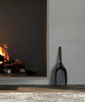 Tough Fireplace Ash Shovel For Indoor Outdoor Use Durable Steel Construction with black powder coated finish leaning by a fireplace.