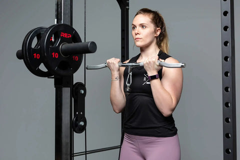 Woman using Multi Grip Curl Bar Attachment for Cable Machines during bicep workout in a gym setting.