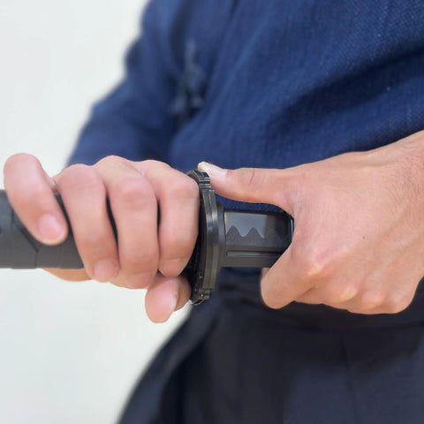 Close-up of hands gripping 39 Inch Polypropylene Martial Arts Training Sword with Black Saya Scabbard for safe training.