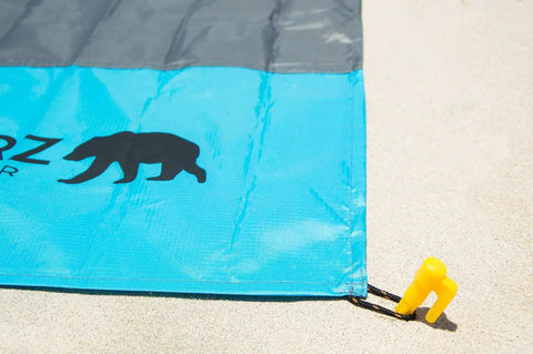Lightweight Beach Tent Stakes Pack Of Four 5.9 Inch Sand Tarp Pegs With Anchor for securing blue and gray tarp on sand