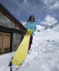Person applying Climb 2.0 Ready Climbing Skin For Backcountry Touring And Ski Mountaineering, 140mm wide, on a snowy mountain.
