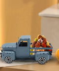 Blue Metal Pickup Truck Decor For Farmhouse Tables carrying colorful decorative balls, displayed on a tabletop