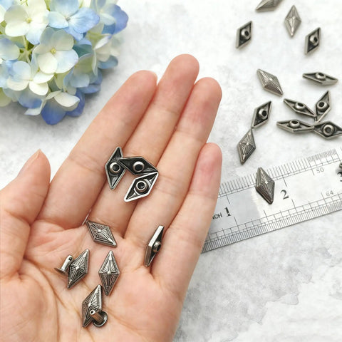 Kickass Diamond Shape Rivets With Screw Back Studs For Leather Crafting and Jacket Embellishment Heavy Duty Zinc Alloy, showing rivets in hand.