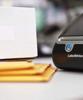 Straight Up Twin Turbo Direct Thermal Label Printer With Dual Roll Setup For Fast Shipping Labels And Office Grind Ink Free Speed for barcodes next to shipping box.