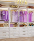 White Modular Closet System, Set Of 4 With 12 Drawers And 8 Rods, top view with purple clothing on hangers and decorative items.