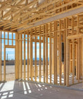 Wood frame of a house under construction using 21 Degree Exterior Galvanized Framing Nails For Wood-To-Wood Builds, Plastic Strip Collated