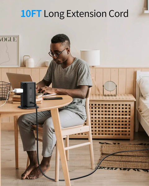 Man using laptop with 10-Foot Power Strip Tower with Eight Outlets and Five USB Ports, Dope Surge Protector on desk.