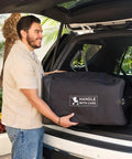 Man placing Universal Stroller Travel Bag For Air Travel: Durable, Padded Go To Case into car trunk