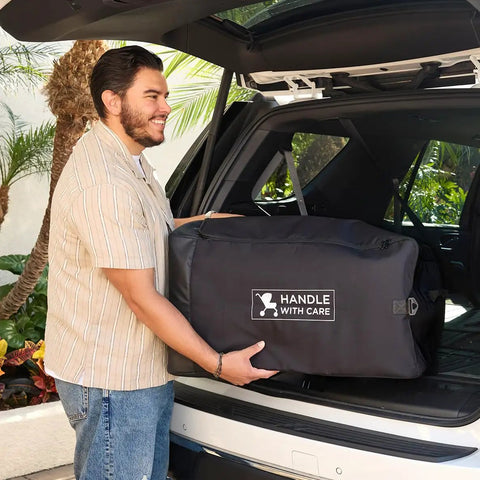 Man placing Universal Stroller Travel Bag For Air Travel: Durable, Padded Go To Case into car trunk